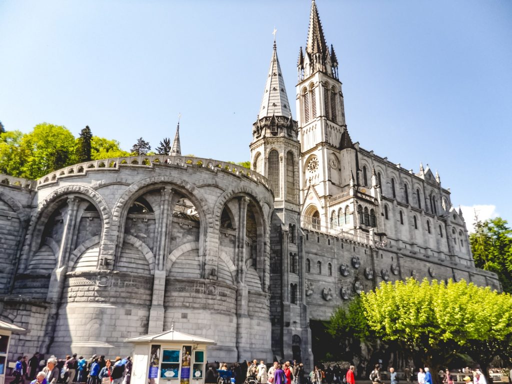Pilgrims and tourists at The Sanctuary of Our Lady of Lourdes - in Lourdes, France.